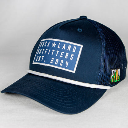 Rock Land Outfitters Blue Logo Patch On A Navy Hat With A White Rope