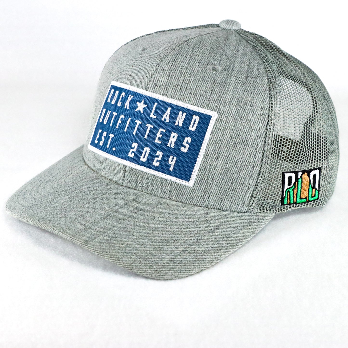 Rock Land Outfitters Blue Logo Patch On A Heather Gray Trucker Hat