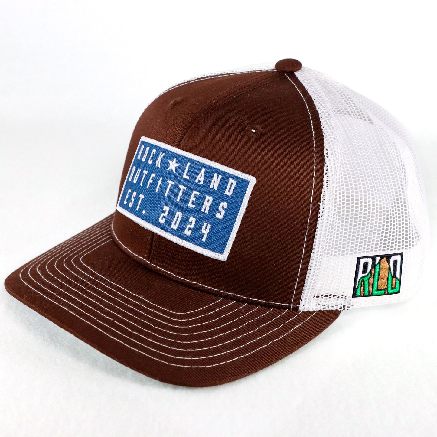 Rock Land Outfitters Blue Logo Patch On A Brown And White Hat